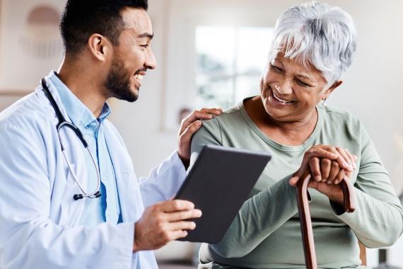 a young doctor sharing information from his digital tablet with an older patient 