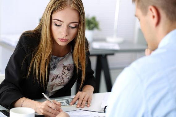 loans_woman_signing_documents_holding_cash_2.jpg