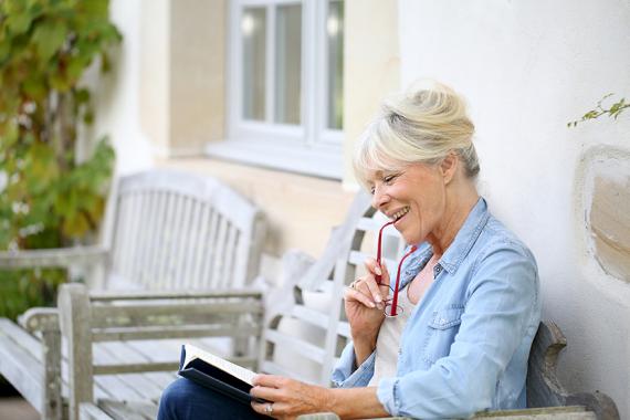 retirement_benefits_senior_woman_reading_porch.jpg